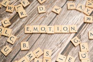 scrabble tiles spelling the word emotion on a wooden surface by Markus Winkler courtesy of Unsplash.